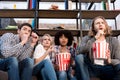 Shocked multiethnic friends watching horror movie