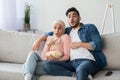 Shocked muslim couple watching thriller on TV