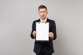 Shocked perplexed young business man in classic black suit hold clipboard with blank empty sheet workspace isolated on Royalty Free Stock Photo