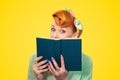Shocked pinup girl hiding herself behind a book Royalty Free Stock Photo
