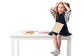 shocked red haired schoolgirl sitting on table and reading book