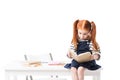 shocked red haired schoolgirl sitting on table and reading book