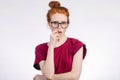 Shocked woman in glasses looking at camera with open mouth and touching head Royalty Free Stock Photo