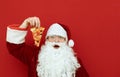 Shocked Santa Claus with a slice of pizza in his hand isolated on red background, surprised looking into the camera, empty space