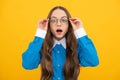 Shocked school aged girl child in spectacles with amazed look yellow background, amazement