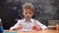 Shocked schoolboy sitting in cloud of smoke, explosion during experiment