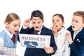 Shocked schoolchildren pretending to be businesspeople reading newspaper Isolated On White. Royalty Free Stock Photo