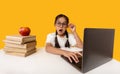 Shocked Schoolgirl Sitting At Laptop Looking At Camera, Yellow Background Royalty Free Stock Photo