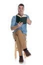 Shocked smart casual man reading a book and gasping