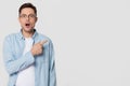 Shocked stunned young man nerd pointing finger aside at copyspace Royalty Free Stock Photo