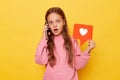 Shocked surprised amazed brown haired little girl, wearing casual clothing looking at camera with big eyes talking on ell phone Royalty Free Stock Photo