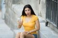 Shocked and surprised attractive young latin woman texting and talking on her smart cell phone Royalty Free Stock Photo