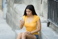 Shocked and surprised attractive young latin woman texting and talking on her smart cell phone Royalty Free Stock Photo