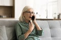 Shocked surprised blonde senior woman talking on cellphone Royalty Free Stock Photo