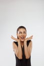 Shocked and surprised girl screaming covering mouth her hands.Beautiful Woman in black dress Royalty Free Stock Photo