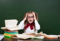 Shocked teen girl near empty green chalkboard