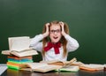 Shocked teen girl near empty green chalkboard