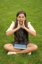 Shocked teen school girl sitting legs crossed on grass. School and education. Back to school Royalty Free Stock Photo