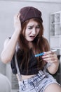 Shocked teenage girl with pregnancy test Royalty Free Stock Photo