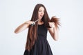 Shocked unhappy woman trimming split ends of hair with scissors Royalty Free Stock Photo