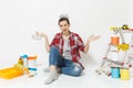 Shocked upset sad woman holds metal grocery baskets for shopping. Instruments for renovation apartment isolated on white Royalty Free Stock Photo