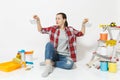 Shocked upset sad woman holds metal grocery baskets for shopping. Instruments for renovation apartment isolated on white Royalty Free Stock Photo