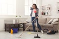 Shocked woman cleaning house with lots of tools