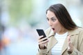 Shocked woman finding surprising news on phone