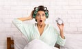 Shocked Woman Holding Clock Being Late Sitting In Bed Indoors Royalty Free Stock Photo