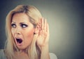 Shocked woman holds her hand near ear and listens carefully Royalty Free Stock Photo