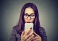 Shocked woman looking at mobile phone Royalty Free Stock Photo