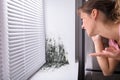 Shocked Woman Looking At Mold On Wall Royalty Free Stock Photo