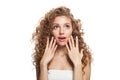 Shocked woman looking up. Healthy female model with natural make-up, shiny clear skin and long curly hairstyle isolated on white Royalty Free Stock Photo