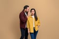 Shocked woman with mouth open listening to man telling secrets into her ear. Young boyfriend whispering gossips to girlfriend Royalty Free Stock Photo