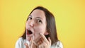 Shocked woman shows big pimple at her face, close up isolated on yellow wall. Problem skin concept Royalty Free Stock Photo