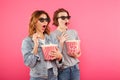 Shocked women friends eating popcorn watch film. Royalty Free Stock Photo