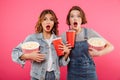 Shocked women friends eating popcorn watch film Royalty Free Stock Photo