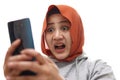 Shocked worried Asian muslim woman worried when reading bad news text message on her smart phone