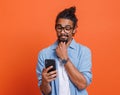 Shocked young african american man reading bad unexpected news on smartphone with opened mouth Royalty Free Stock Photo