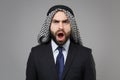 Shocked young bearded arabian muslim businessman in keffiyeh kafiya ring igal agal classic black suit shirt isolated on Royalty Free Stock Photo