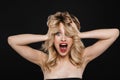 Shocked young blonde woman with bright makeup red lips posing isolated over black wall background Royalty Free Stock Photo