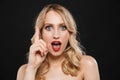 Shocked young blonde woman with bright makeup red lips posing isolated over black wall background Royalty Free Stock Photo