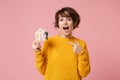 Shocked young brunette woman girl in yellow sweater posing isolated on pastel pink background in studio. People