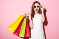 Shocked young brunette woman with shopping bags