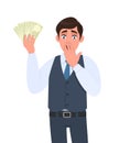 Shocked young businessman in waistcoat showing cash, money and covering hand on mouth. Scared person holding currency notes. Royalty Free Stock Photo