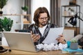 Shocked young caucasian man sitting at table with modern laptop at home office Royalty Free Stock Photo