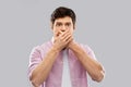 Shocked young man covering his mouth by hands Royalty Free Stock Photo
