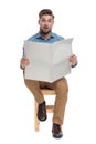 Shocked young man in denim shirt reading newspaper Royalty Free Stock Photo