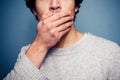 Shocked young man with his hand on his mouth Royalty Free Stock Photo