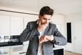 Shocked young man in suit looking at his wrist watch Royalty Free Stock Photo